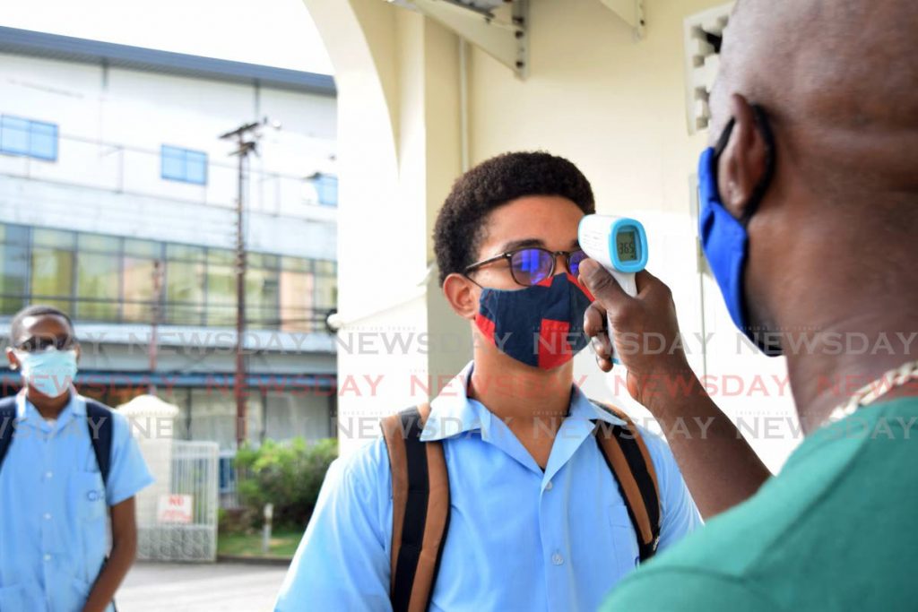 HEAT CHECK: An official checks the temperature of a Form 6 CIC student on Tuesday morning before the start of CSEC exams.  - Vidya Thurab