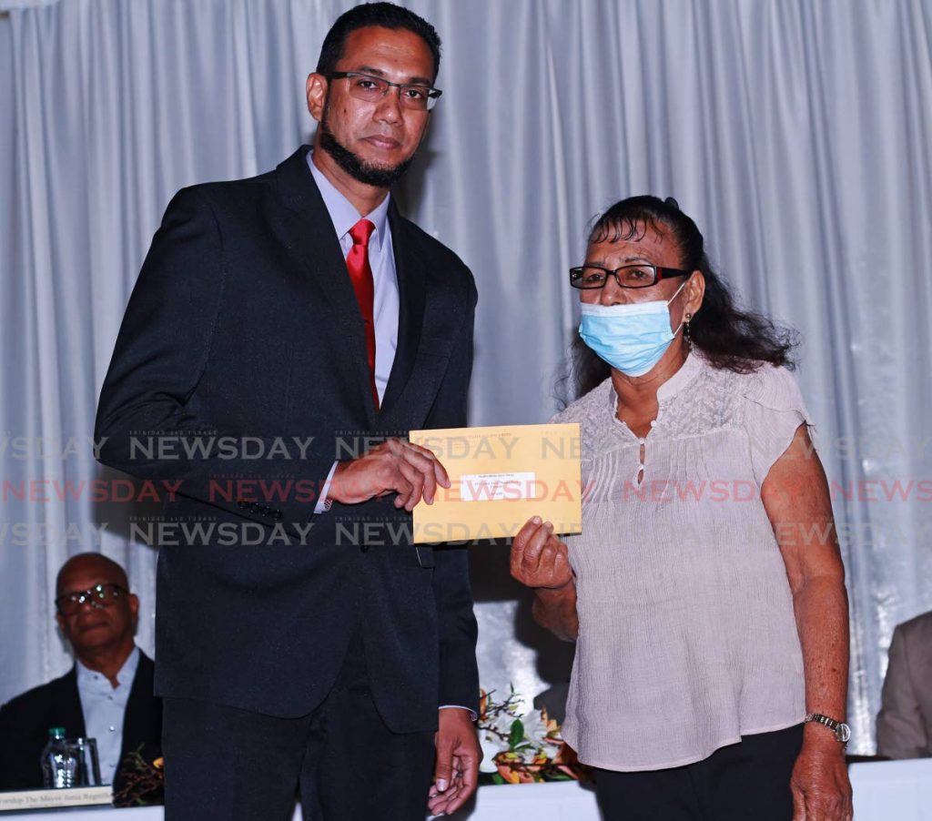 Prospective PNM candidate for Caroni Central Reyad Ali, left, presents Sandra Maraj with a self help grant at a distribution ceremony at San Fernando City Hall, on Tuesday. - CHEQUANA WHEELER