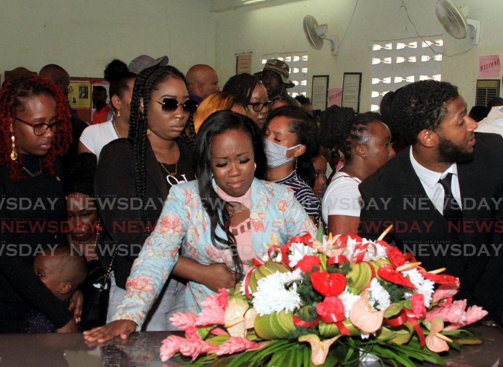 HE’S GONE: Sade Samuel, centre, at the coffin of her fiancé, murdered dancehall singer Kyle “Rebel Sixx” George, during his funeral on Tuesday.  - Ayanna Kinsale