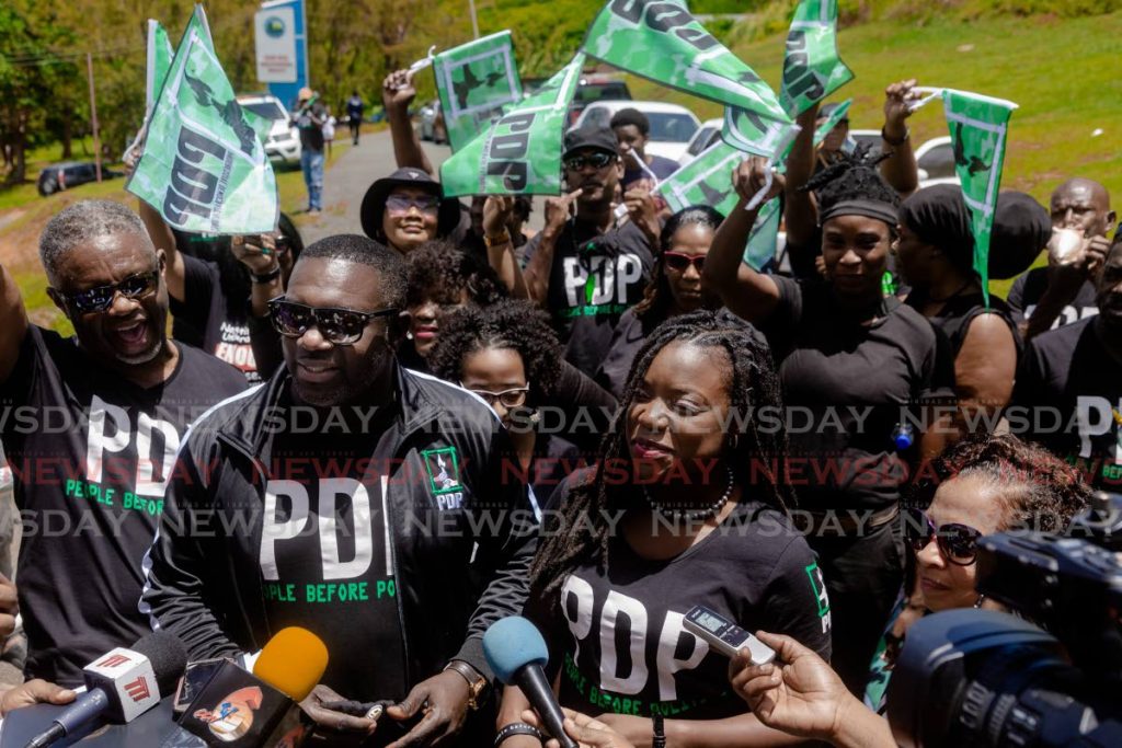 PDP Tobago East candidate Watson Duke, second from left, accompanied by the party's Tobago West candidate Tashia Grace Burris as well as family and party supporters, speaks to media before filing nomination papers on Friday at the John Dial Multipurpose Facility, Tobago. - David Reid
