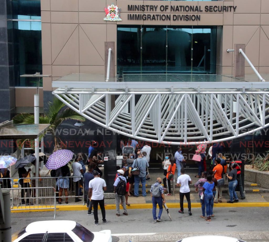 Large group of persons outside waiting to be let in at the Immigration Division of the Ministry of National Security on Richmond Street in Port of Spain. - SUREASH CHOLAI