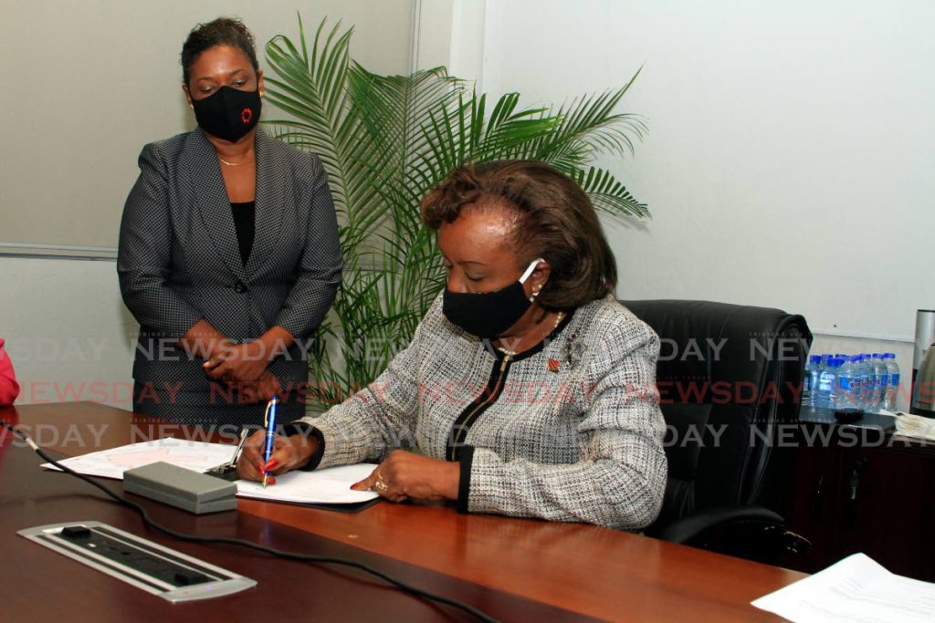 Chairman of the South West Regional Health Authority (SWRHA) Valerie Alleyne-Rawlins signs the official deed for the San Fernando Waterfront car park at UDECOTT's head office on Sackville Street, Port of Spain. - Ayanna Kinsale