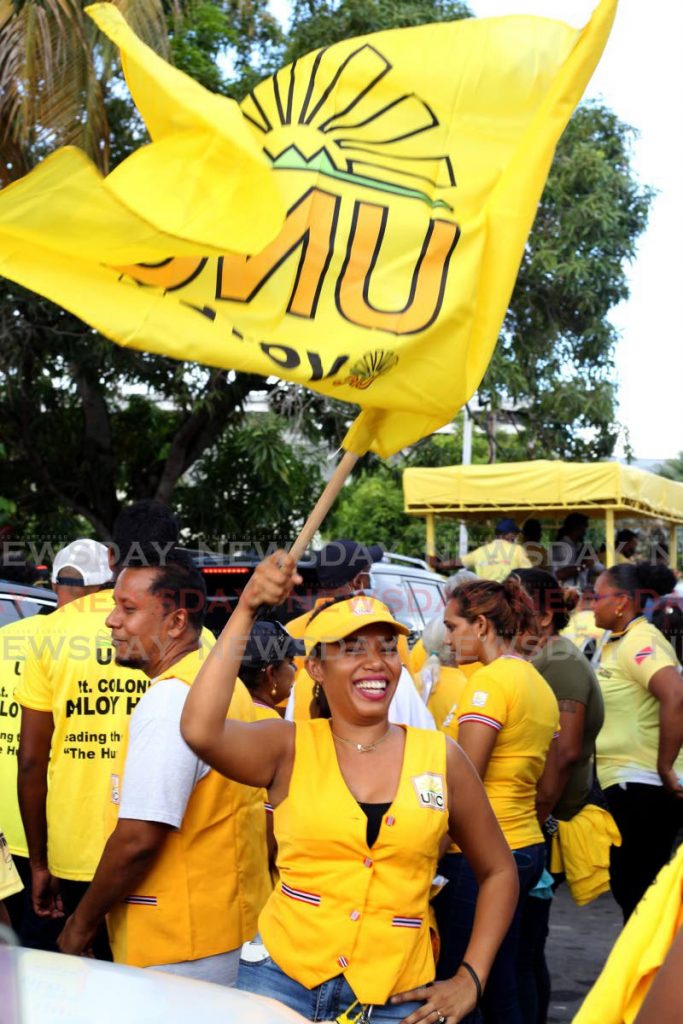 FLAG-BEARER: A UNC supporter waves her flag during a walkabout in Aranguez on Tuesday by the party’s St Joseph general election candidate Ahloy Hunt. 
 - ROGER JACOB