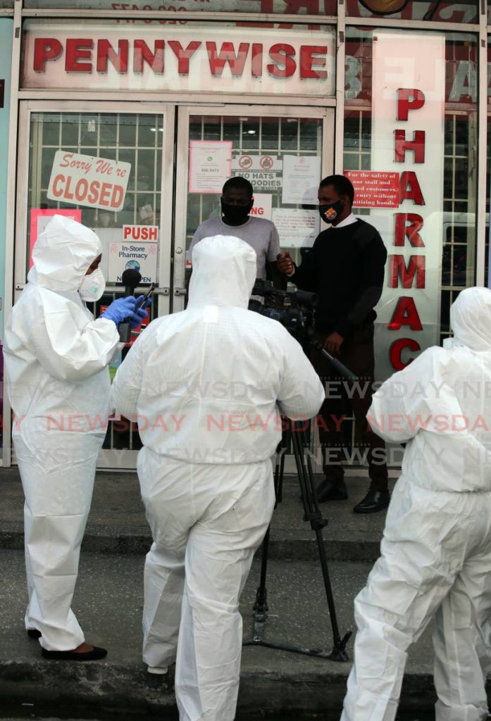 A covid 19 scare at Pennywise  store on Charlotte Street in Port of Spain, caused the management to closed the store with the workers inside , in photo media workers outside wearing  personal protection suits for their safety  covering  the story. - SUREASH CHOLAI