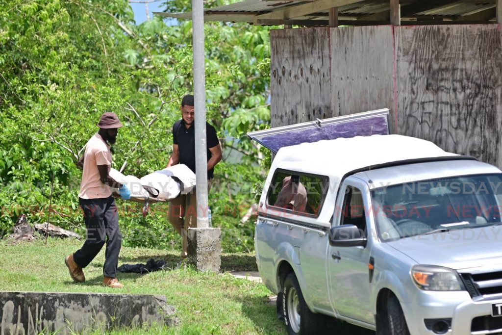 MURDER SCENE: Undertakers remove the body of James Ferguson who was one of two men killed on Tuesday night on St Cecilia Road, Concordia in Tobago. - LEEANDRO NORAY