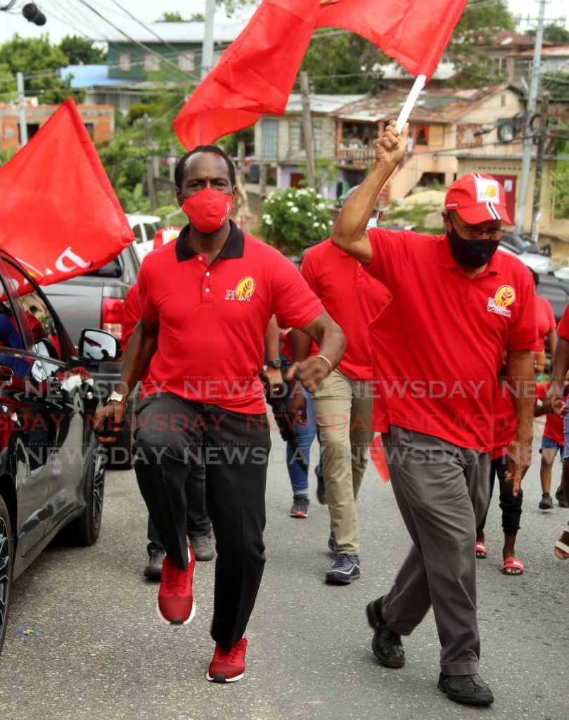 MARCHING ON: PNM Laventille West general election candidate Fitzgerald Hinds, left, marches during his campaign walkabout on Thursday in St Barb’s.  - SUREASH CHOLAI