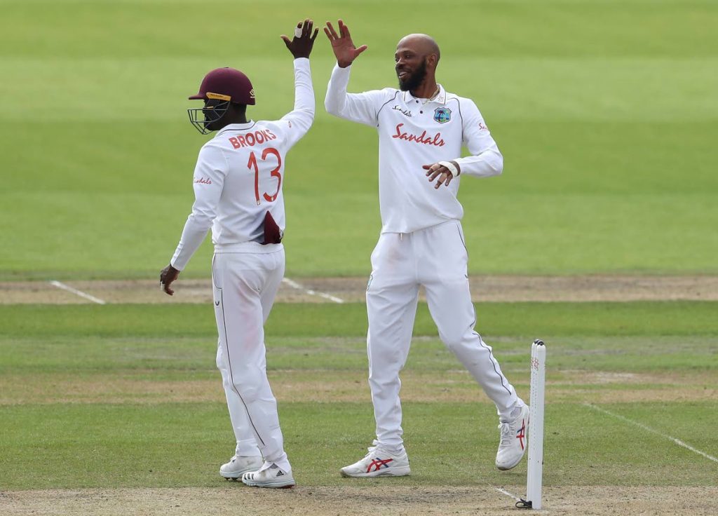 West Indies' Roston Chase (right), celebrates the dismissal of England's Rory Burns during the first day of the third Test match between England and West Indies at Old Trafford in Manchester, England, on Friday. - 