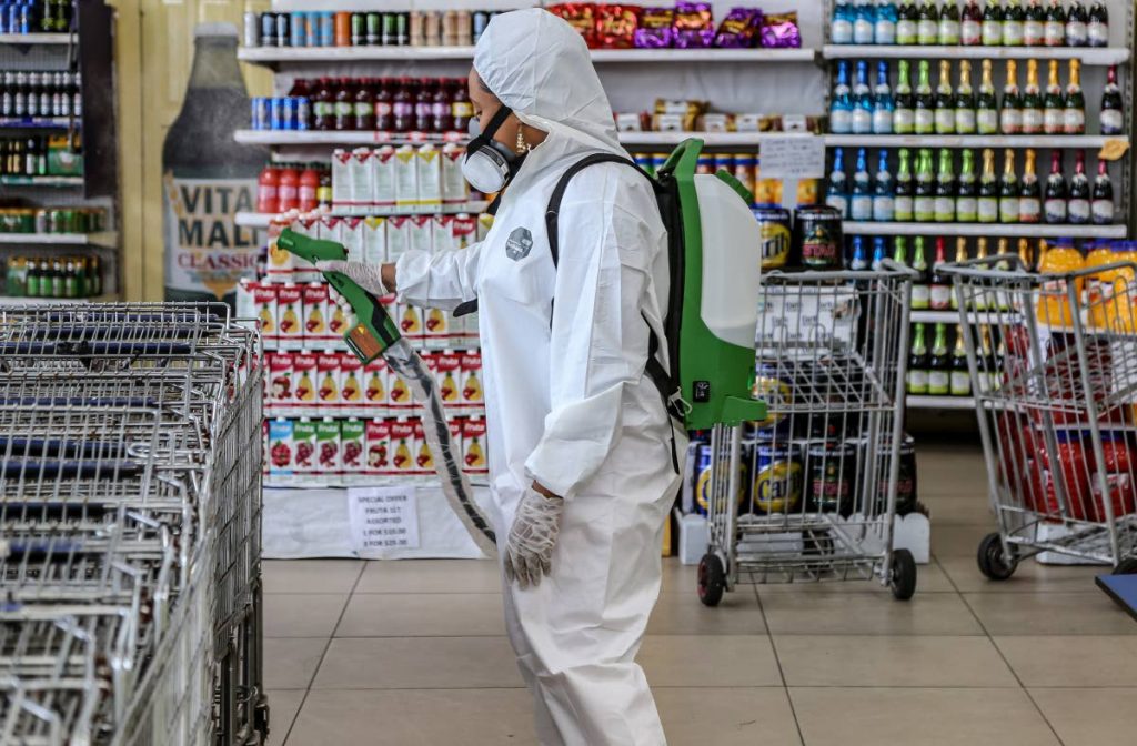 An employee of Trinidad Innovation sanitises a supermarket in San Juan on Friday after reports that someone who tested positive for covid19 had been to the location. PHOTO BY JEFF MAYERS - 