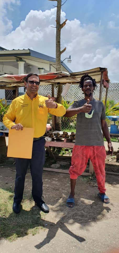 Dr Rishad Seecheran gives thumbs up with a Kelly Village resident duing his walkabout on July 17. Seecheran entered politics after seeing the difficulty faced by many in TT.  - Photo taken from UNC Caroni East Facebook page 