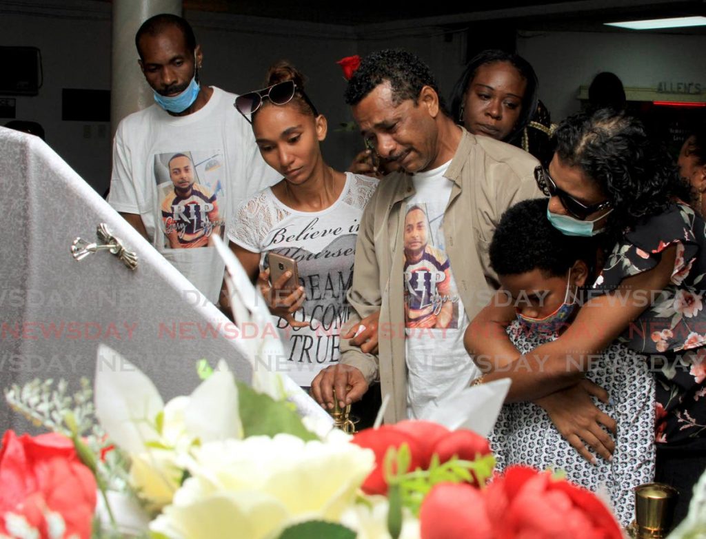 SORROW: Relatives of Gary Layne, the man found hanging in a holding cell at the Arouca police station, say their final farewell at his funeral on Monday in Arima. - Ayanna Kinsale