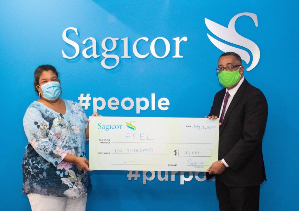 FEEL CEO Elena Villafana Sylvester, left, receives a cheque from Sagicor branch manager Christopher Gouveia, at Sagicor’s Head Office in Port of Spain. - 