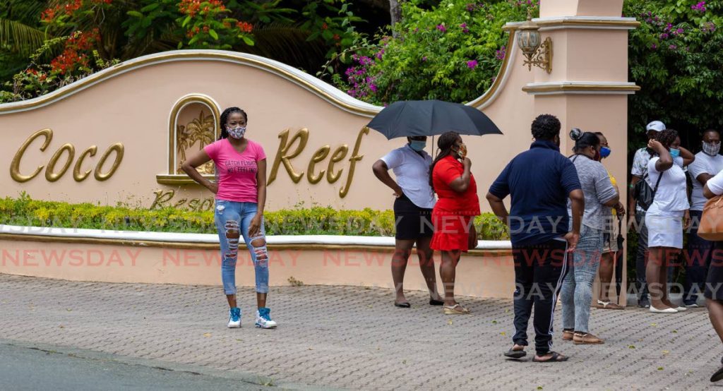 Coco Reef Resort workers gather at the entrance to the hotel recently to protest a decision by management to send them home without pay for two more months. - DAVID REID