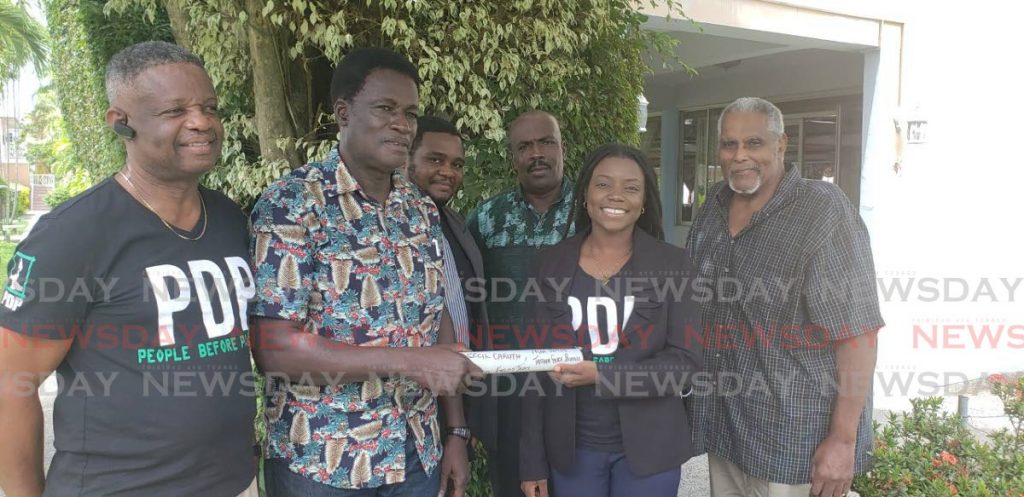 PDP's Tobago West candidate Tashia Grace Burris, second from right, accepts the symbolic baton from Regis Caruth to fight for self governance. They are flanked by PDP's Vice Chairman Andre Cowan, Chairman Dr Sean Nedd, Burris' father Gairy Burris and George Stanley Beard - Kinnesha George-Harry 