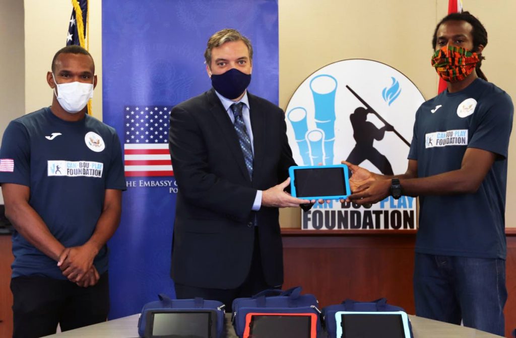 US Embassy’s deputy chief of mission Joseph FitzGerald, centre, presents the tablets to Yohance Marshall, right of Can Bou Play Foundation. Looking on is Akim Armstrong, a member of the Foundation.  - 