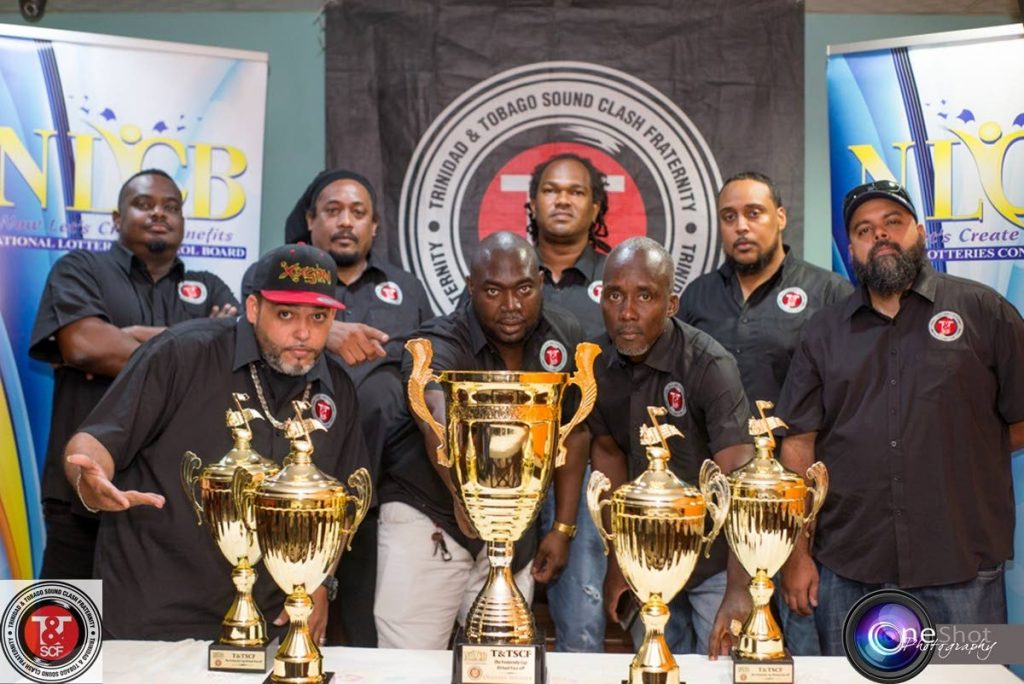Executive members of the TT Sound Clash Fraternity pose with some of the trophies up for grabs at the sound clash competition. - 