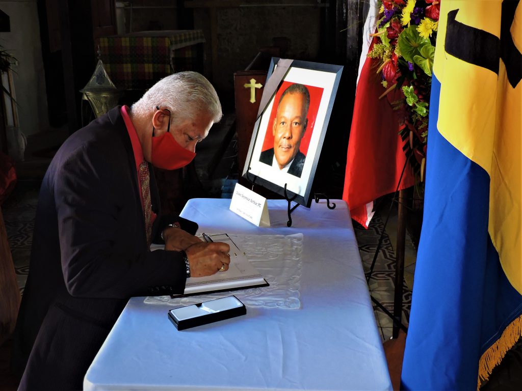 Port of Spain mayor Joel Martinez signing book in honour of former Barbados Prime Minister Owen Arthur 