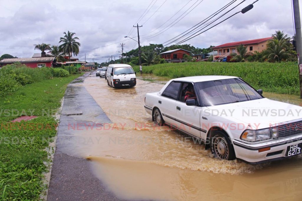 File photo: Drivers proceed cautiously through a flooded road in Barrackpore after heavy rainfall on August 9. 
PHOTO BY CHEQUANA WHEELER 