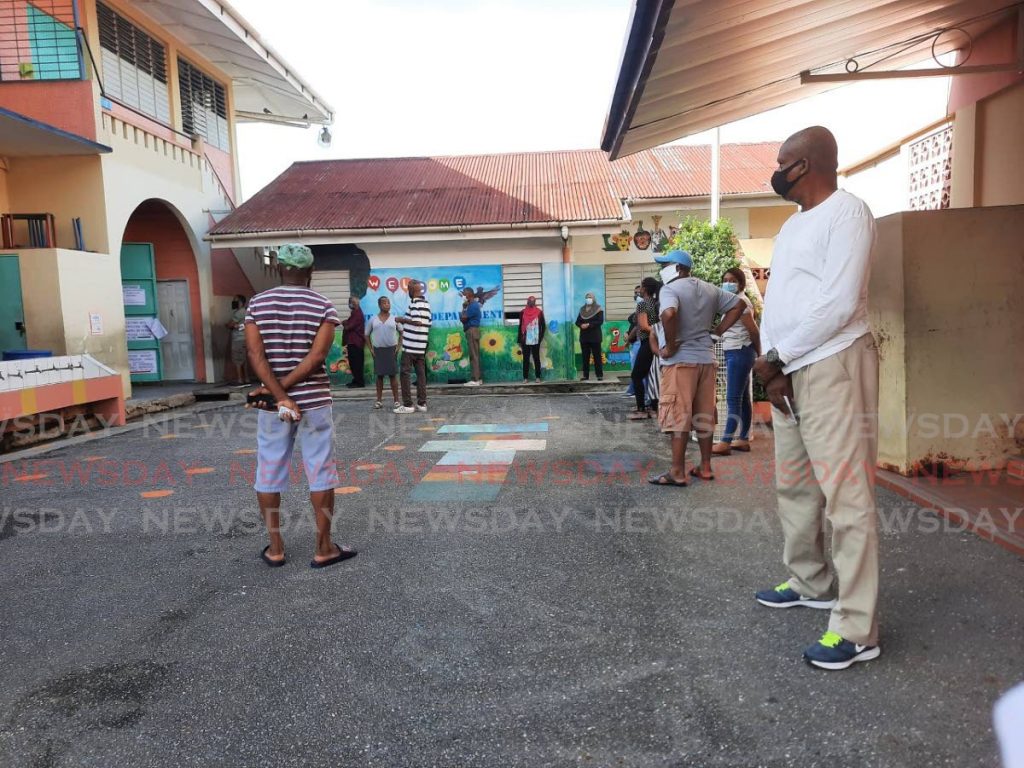 Voters line up at the Curepe Presbyterian Primary School on Monday. - PAULA LINDO