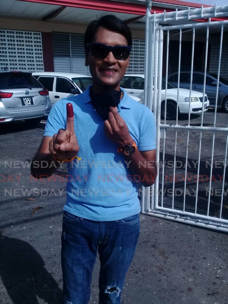 Princes Town UNC Barry Padarath shows his stained index finger after he voted at the Couva Anglican Primary School on Monday morning. - Angelo Marcelle