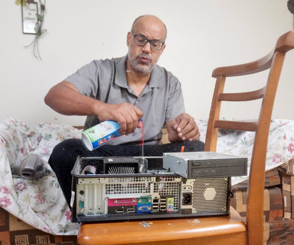 Simon Fraser cleans a donated desktop system at his home - Mark Lyndersay