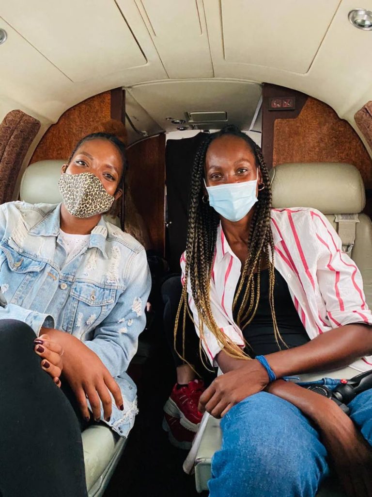 Returning European-based volleyball players Channon Thompson, left, and Krstle Esdelle, aboard their chartered flight en route to TT over the weekend.  - Channon Thompson