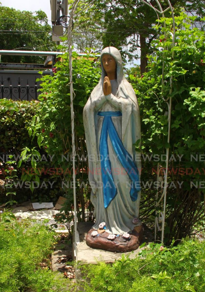 The Holy Virgin Mary divine statue with praying hands faces the garden. - ROGER JACOB