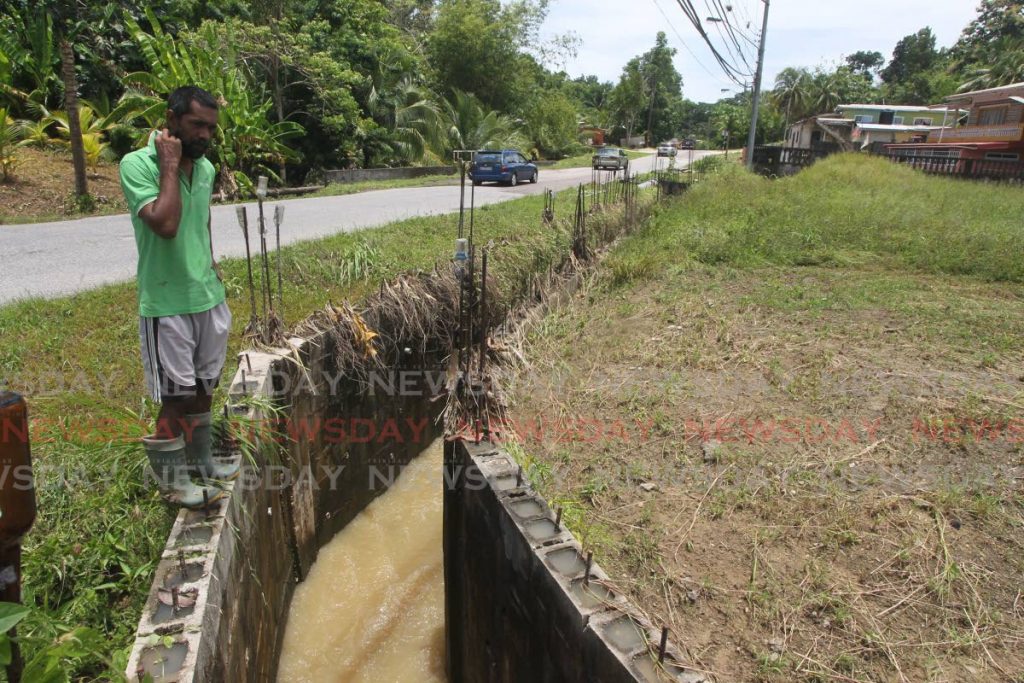 Agostini Village, Rio Claro, resident  Donald Ramsaroop stands next to a box drain that was constructed to divert a watercourse in the area. The drain is being blamed for Sunday's flooding. - Lincoln Holder