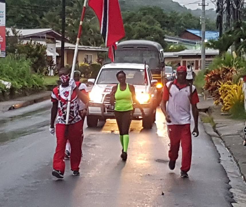 TT's official flag-bearer David Nelson, left, leads a walk from Charlotteville to Crown Point on Monday to mark this country's 58th anniversary of independence. PHOTO COURTESY TOBAGO SPORTS LIVE - 