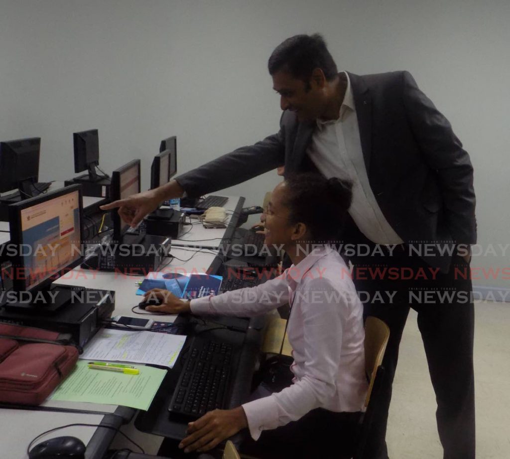In this March 23, 2019 file photo business systems manager for CrimsonLogic Madhukeshwara Bhavi, right, instructs Angelique Najab-Antoine of NH International Ltd on how to use the Ministry of Planning and Development's digital portal. Digital development will be part of the new Ministry of Public Administration and Digital Transformation. - Shane Superville