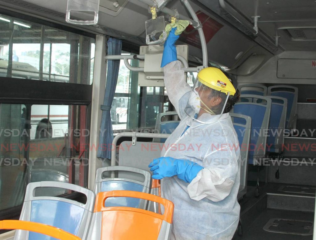 Poonai Sooknanan of the engeneering department at the Public Transport Service Corporation (PTSC) sanitises a bus at City Gate, Port of Spain earlier this year.  - Ayanna Kinsale