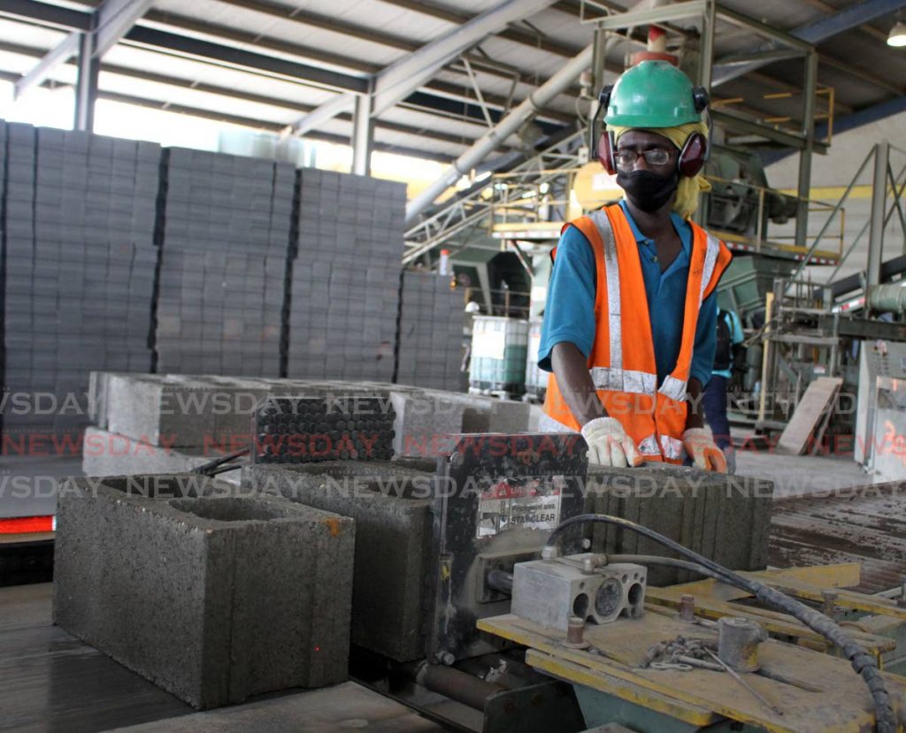 A Coosal’s Construction Co Ltd employee wears a mask while operating a conveyance belt at the the company’s Madras Settlement Road, Chin Chin, Cunpuna. The cement block manufacturer operates under the covid19 health and safety protocols on May 25, 2020. 
PHOTO BY ANGELO MARCELLE - 