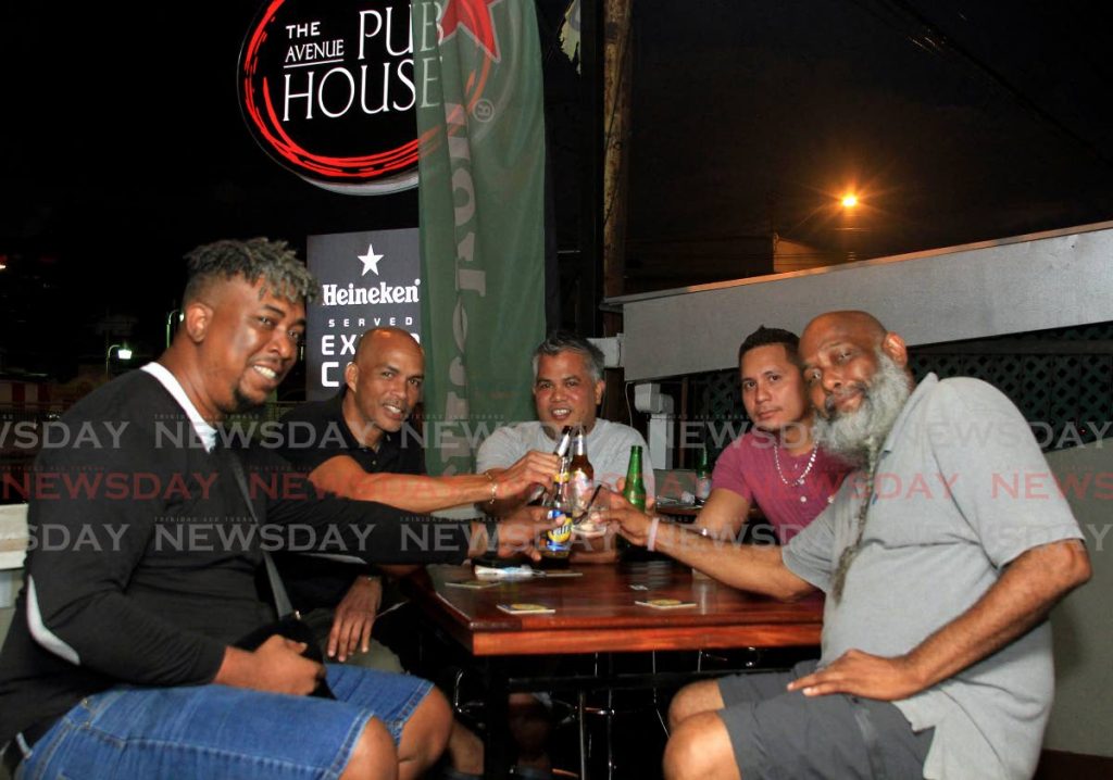 In this July 20 file photo, a group of friends enjoy a rounds at The Avenue Pub House, Ariapita Avenue, Woodbrook. From Monday, drinking at bars will no longer be allowed, only pick up sales, as part of roll back measures during to a spike in covid19 cases. - Ayanna Kinsale