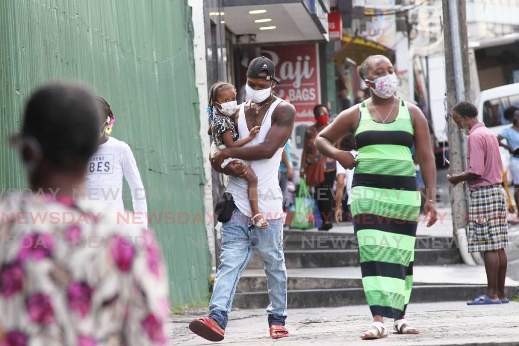 DOING THE RIGHT THING: These people on High Street in San Fernando ensure they adhere to the new law which requires anyone eight years and over to wear a mask while in public. - Lincoln Holder