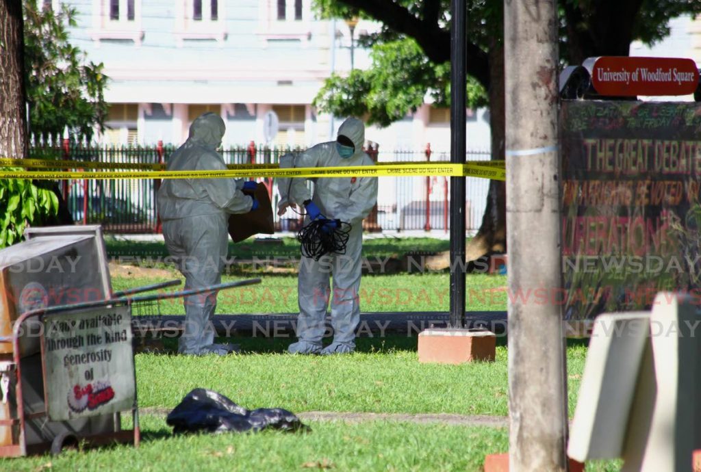 Crime scene investigators collect evidence at the scene of a death by suicide in Woodford Square, Port of Spain last Wednesday. - ROGER JACOB
