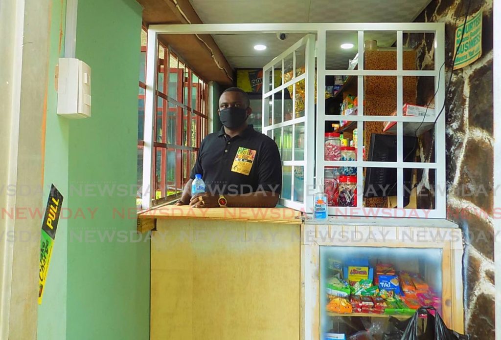 David Hartman sits behind the counter of his Marie Road, Morvant, mini mart. Hartman toyed with the idea of opening his own grocery but took it seriously after his daughter’s birth seven yeas ago and the death of his mother last January. - Shane Superville