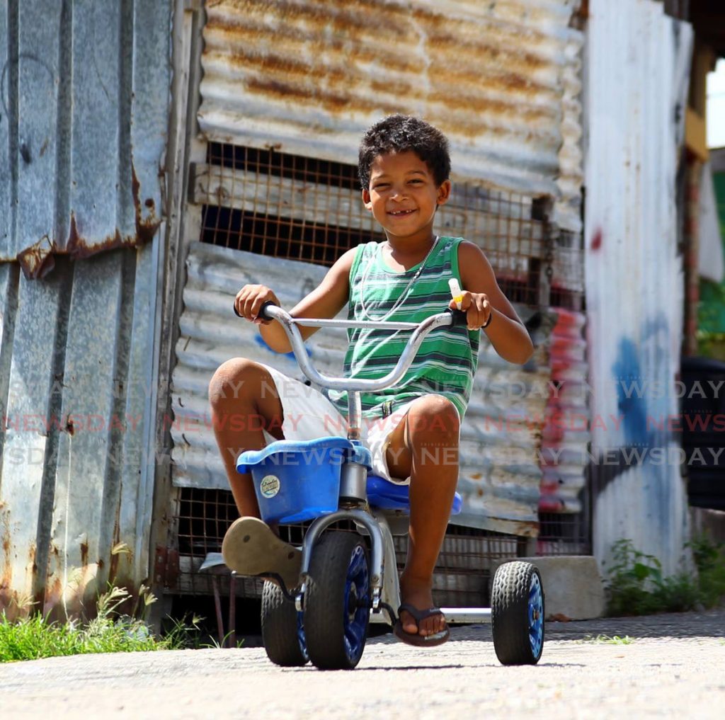 Justin Matters 7, rides his tricycle along the pathway on the hill top in Dan Kelly village, Dan Kelly Laventille. Photo by Roger Jacob - 