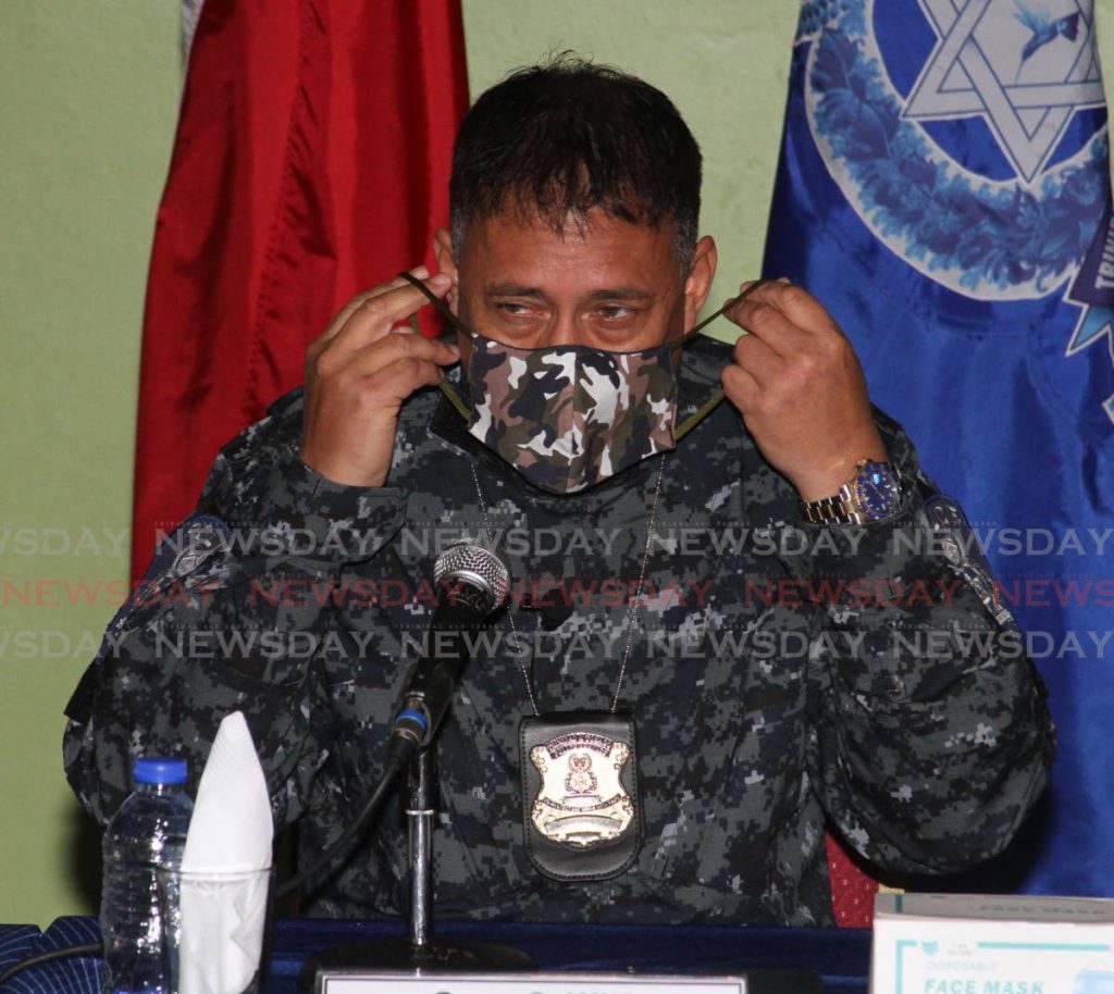 In this file photo, Police Commissioner Gary Griffith puts on his mask during a media briefing at the Police Administration Building in Port of Spain. - Angelo Marcelle