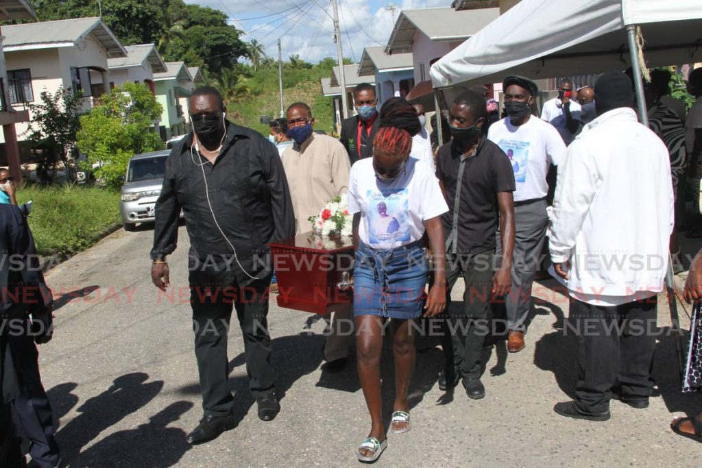 Relatives carry the body of Venrick Hudlin after his funeral at his family's Rich field Gomez trace St Mary's, Moruga, home on Saturday. - Lincoln Holder