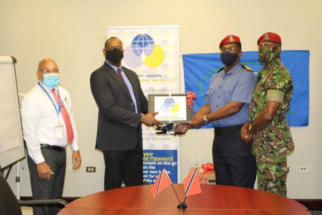 Clico Credit Union’s senior business development officer Fred Vidale and CEO Niall Legerton hand over a computer to Milat’s Cpt Douglas Archer and Major David R Benjamin.  Photo courtesy Clico Credit Union - 