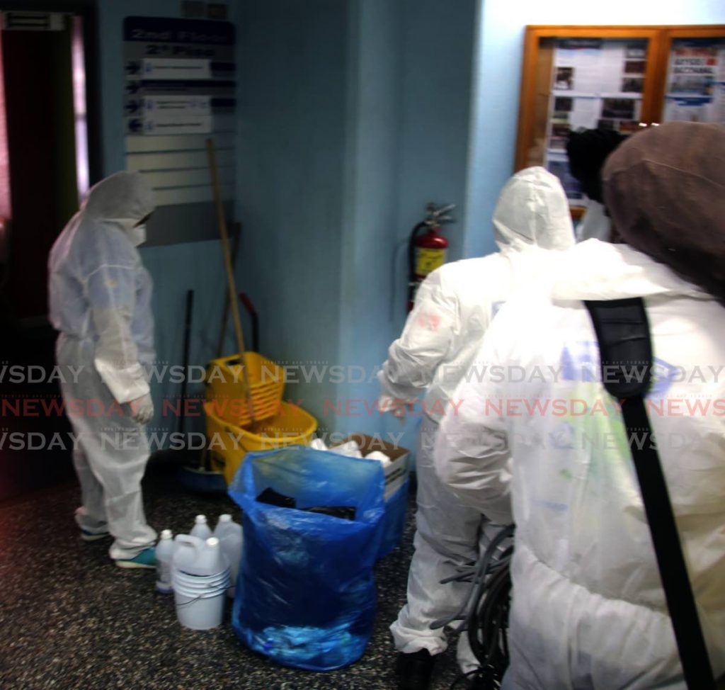 A crew at work sanitising two floors of the Police Administration Building in Port of Spain on Wednesday. - SUREASH CHOLAI