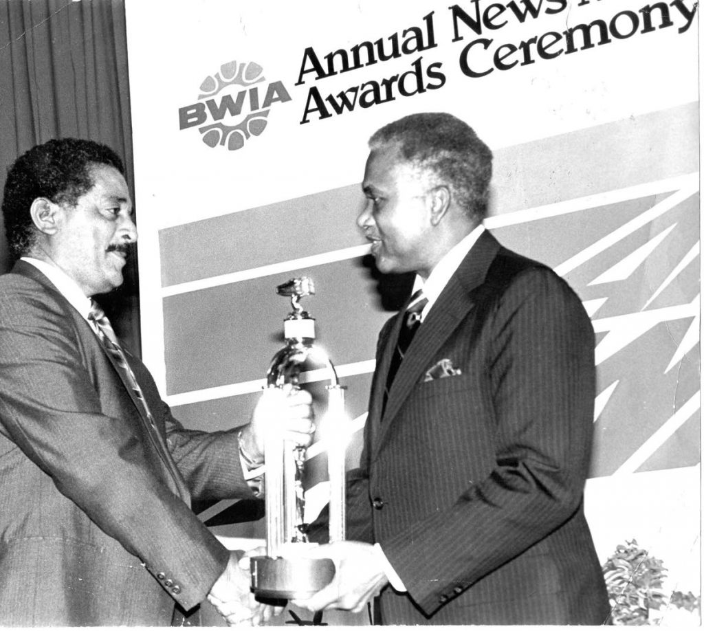 Journalist Owen Baptiste receives an award from Arthur NR Robinson at the BWIA Awards. PHOTO TAKEN FROM FACEBOOK - 
