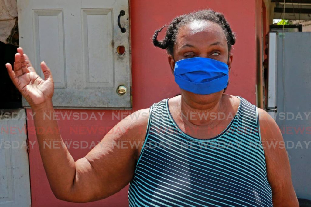 Visually-impaired Sharlene Downes explains how her family's home on Caratal Road, Gasparillo was damaged by heavy rain and strong winds on Saturday morning. PHOTOS BY MARVIN HAMILTON - 