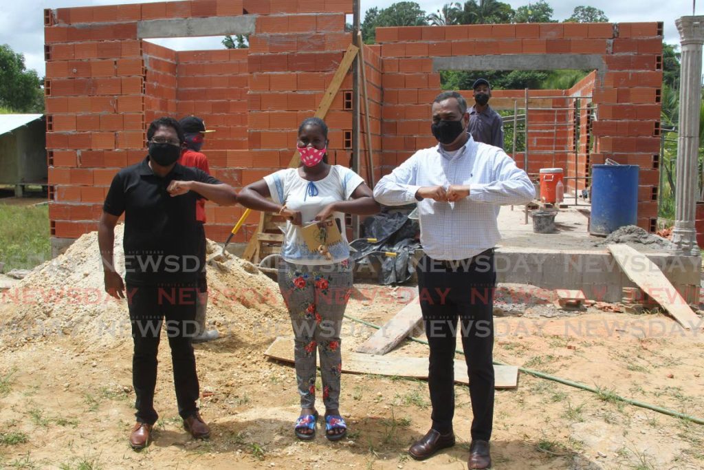 Meera Boodram is flanked by Rahim Mohammed executive manager-corporate services and Glen Mahabirsingh, general manager operations at Coosal's during a visit to the home she and her siblings are building at Wilson Road, Penal. - Lincoln Holder