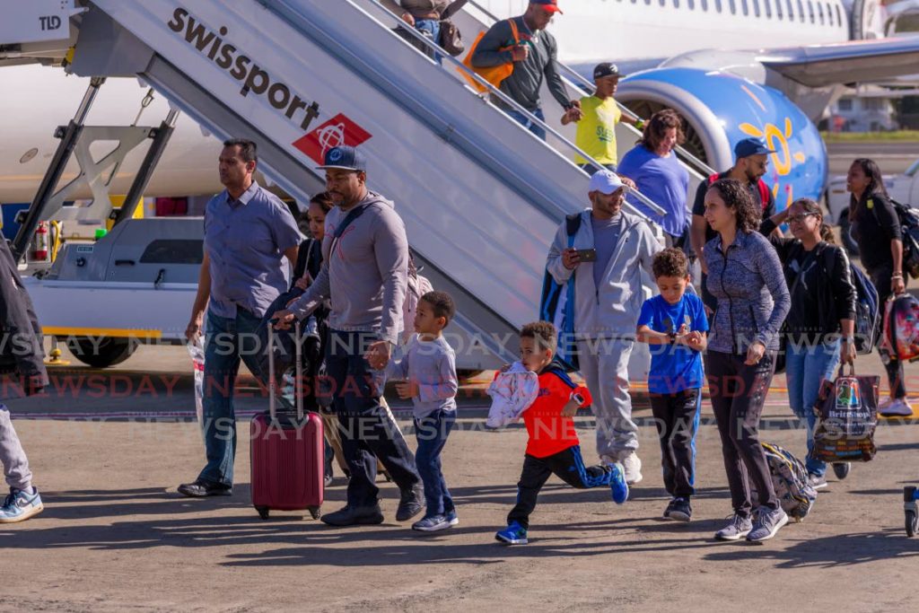 Passengers disembark Sunwing Airlines' inaugural Toronto to Tobago flight at the ANR Robinson International airport in 2018. - 