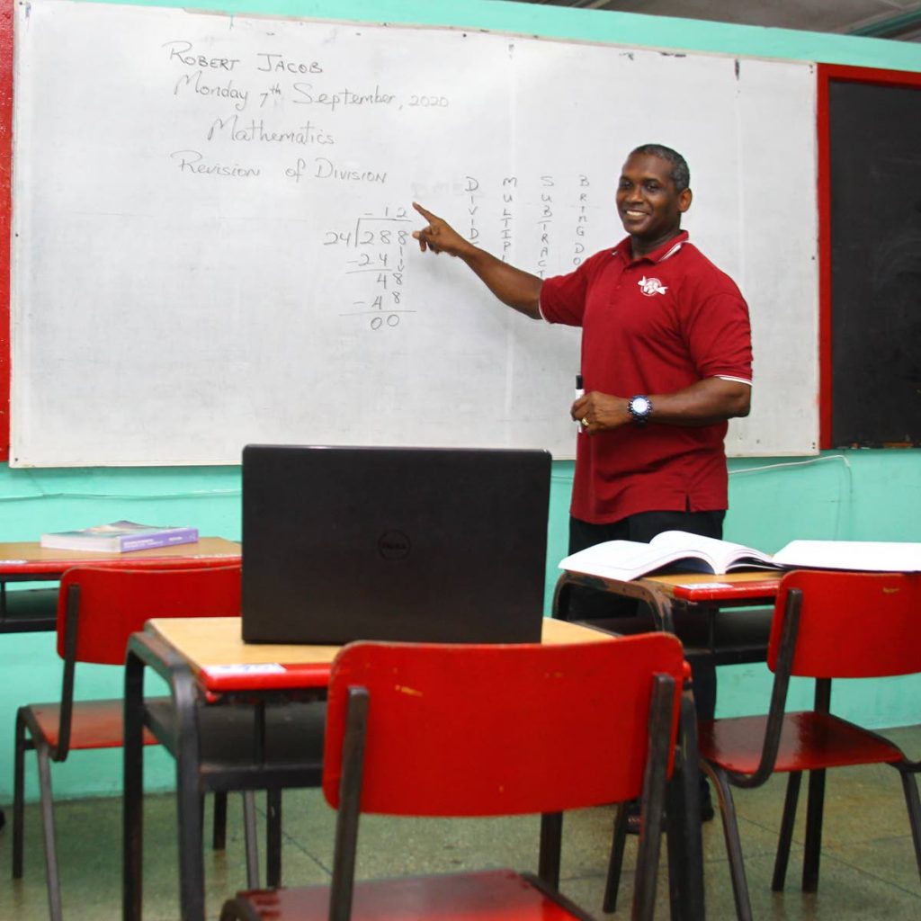 Standard four teacher Robert Jacob conducts an online class for his at-home students from a classroom at Barataria Anglican Primary School. Teachers  say they have to use their resources to prepare study packages for students who cannot access online classes. - 
