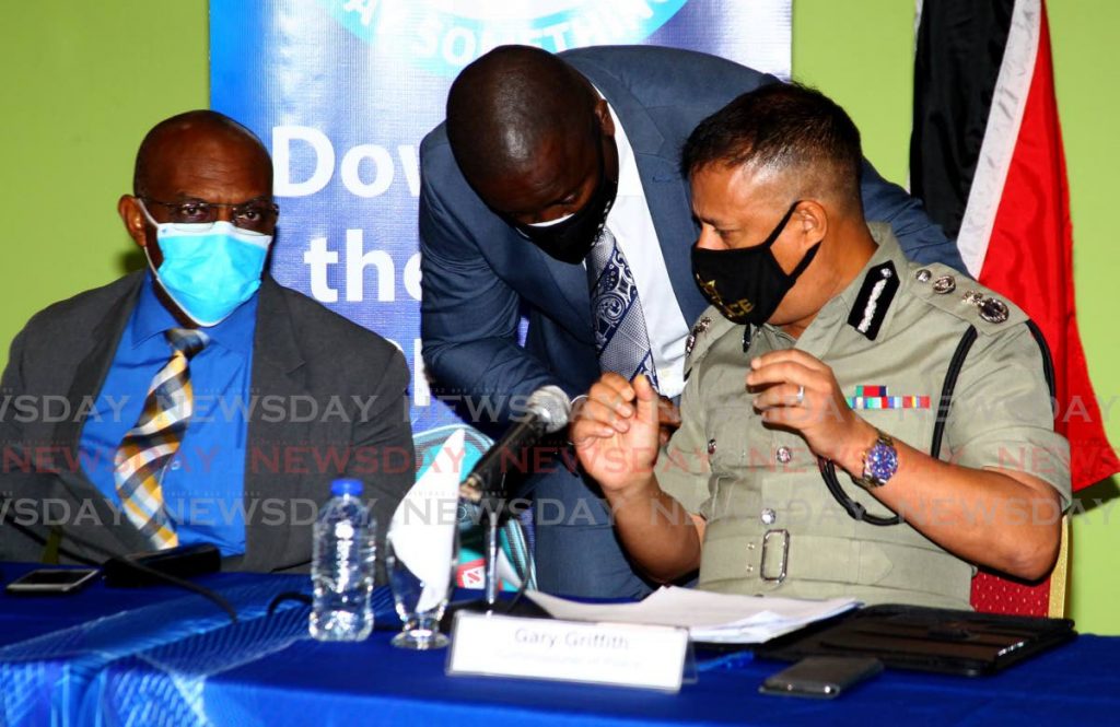MASKED TALKS: Police Commissioner Gary Griffith speaks with Supt Wendell Lucas of the Financial Investigations Unit while Acting Deputy Commissioner Jayson Forde, left, listens on Thursday at a press briefing at Police Administration Building in Port of Spain.  - ROGER JACOB