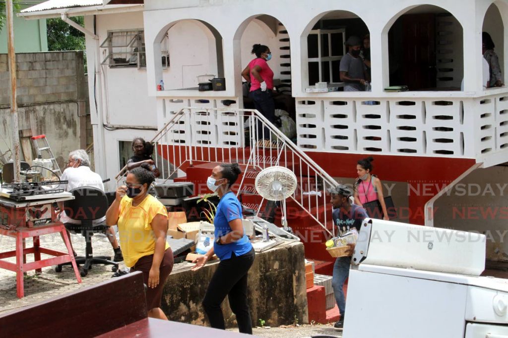 Family and friends of TV personality Errol Fabien help secure equipment and household items in the yard of the building which houses his gayelle television station. - Angelo Marcelle