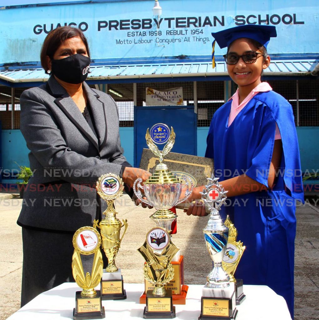 Guaico Presbyterian Primary School principal Indira Rambaran-Mohammed presents valedictorian Traveer Pattron with an award at the school on Wednesday. PHOTO BY ROGER JACOB - 