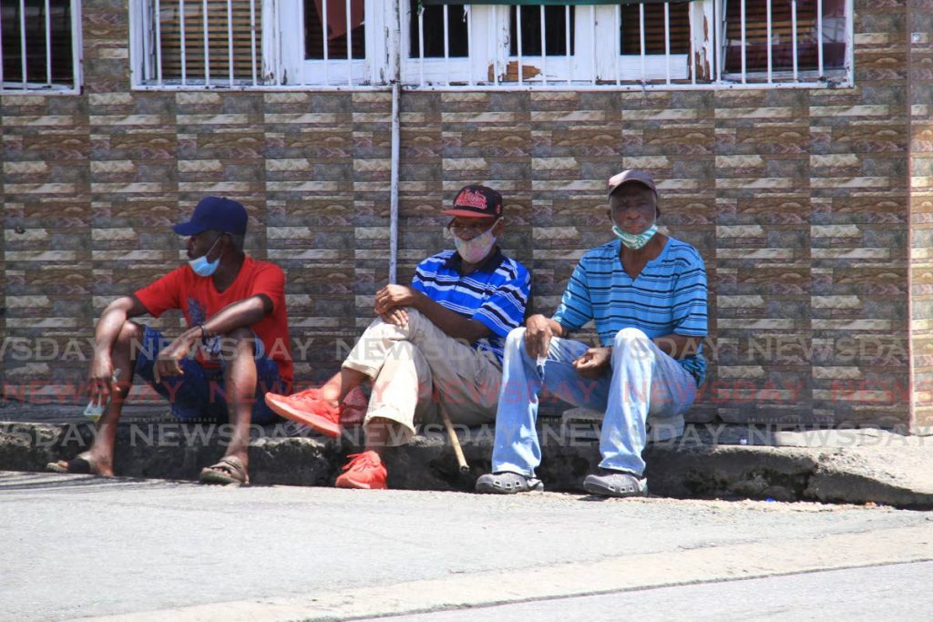 Three friends relax on the pavement on Milford Road, Scarborough, Tobago. - Ayanna Kinsale 