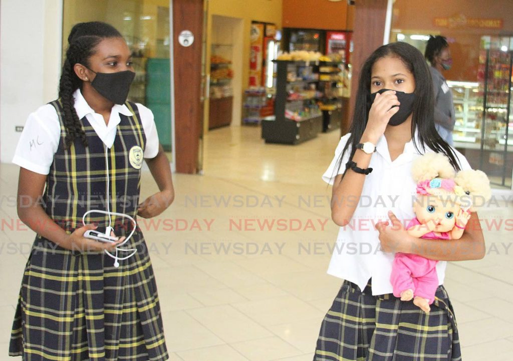 Darcel Diaz and Kelis Diaz-Mc Gillvary, both 11, of Victory Academy of Learning, walk through Trincity Mall on Thursday after getting their S.E.A results.

PHOTO:ANGELO M. MARCELLE 